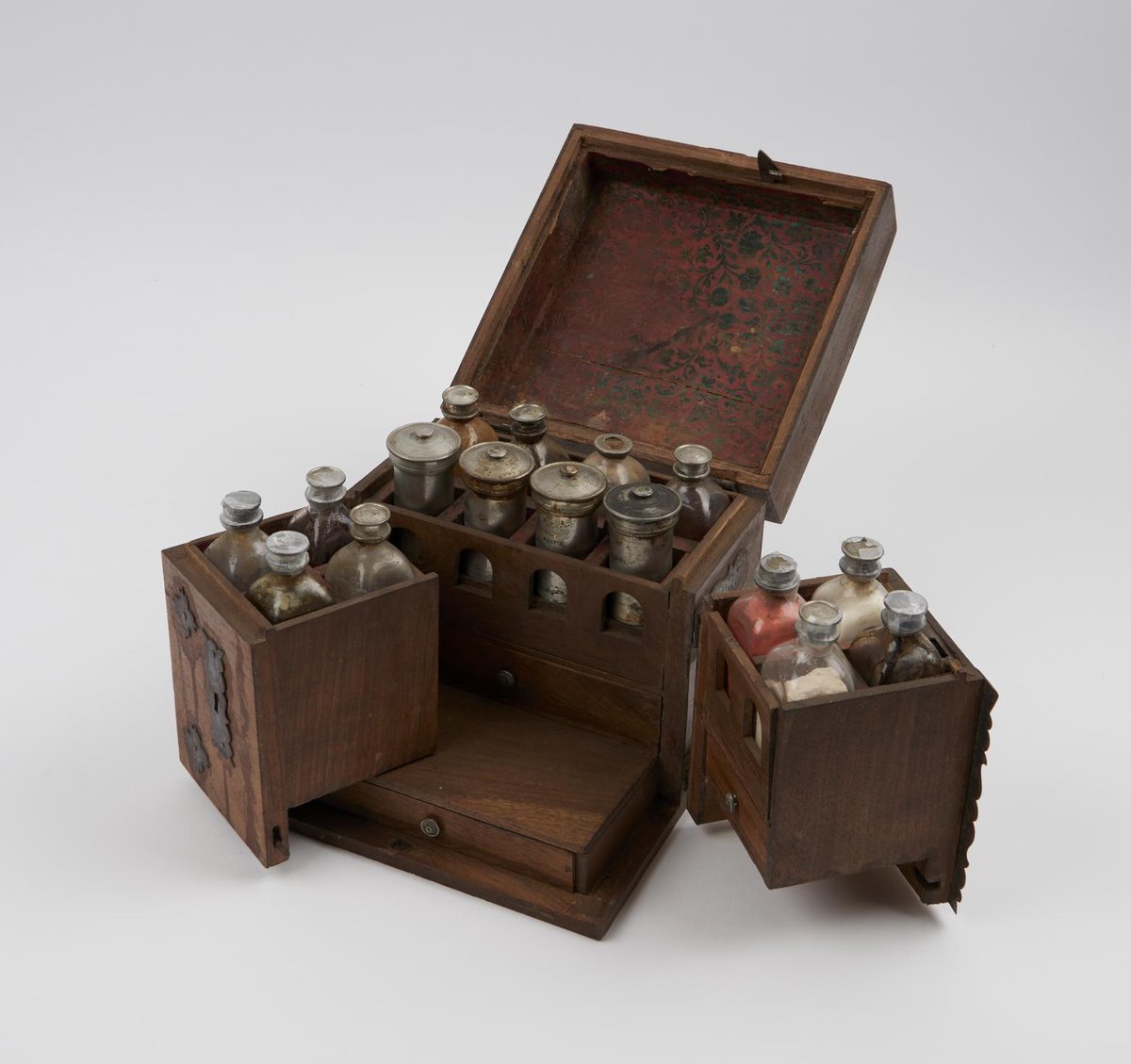 Wooden medicine chest, hinged lid, swing back fronts, iron fittings, compartments for drug bottles (12) and pewter canisters (4), drawers below for scales, weights, mortar and pestle etc., German, 1731-1850. Science Museum.