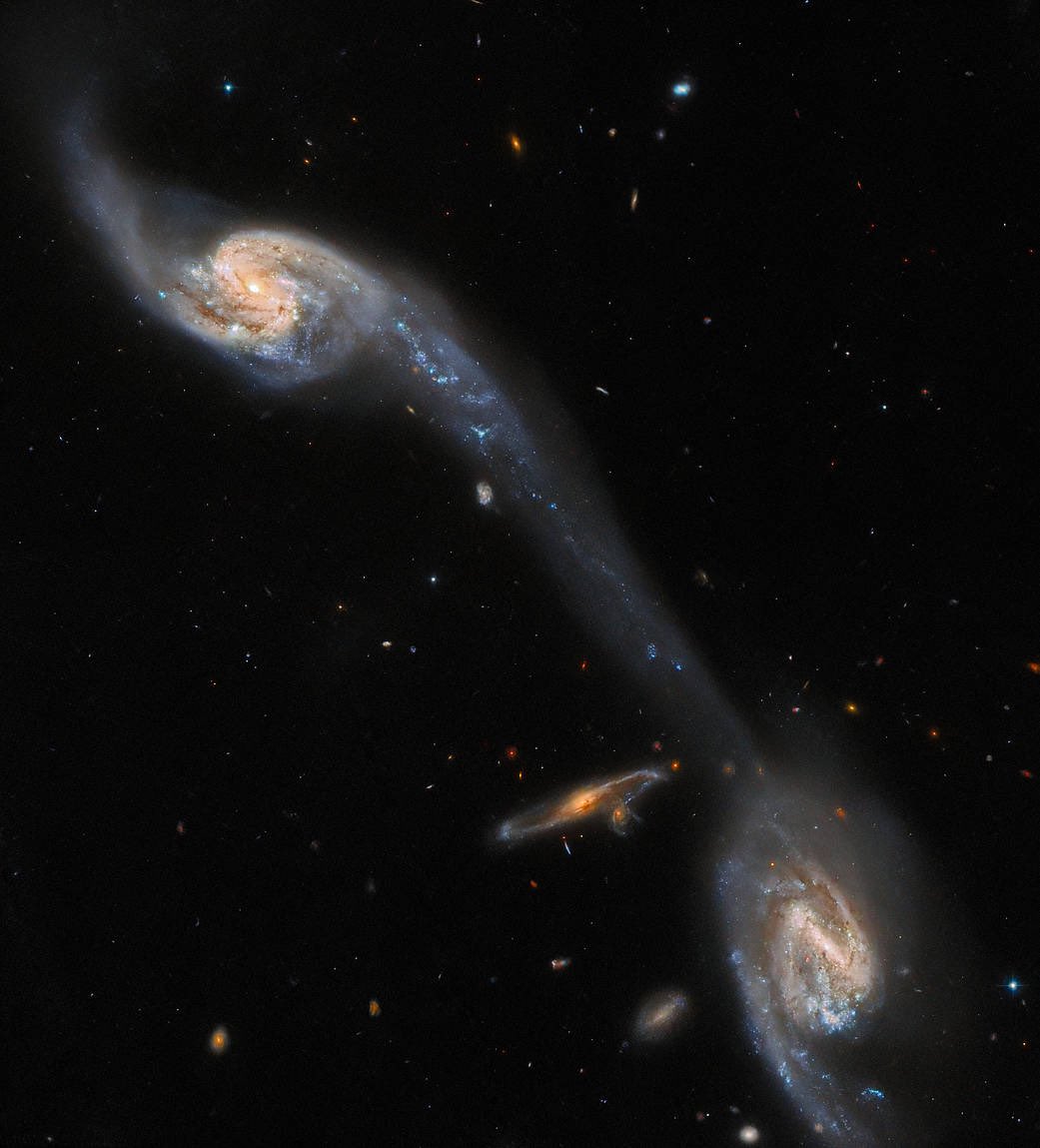 astro_jaz's tweet photo. Take a look at this. 
Two galaxies connected by a cosmic bridge. 
This is known as a tidal tail, formed by the mutual gravitational attraction of the galaxies. Space is stunning. https://t.co/LuCt0aeLel
