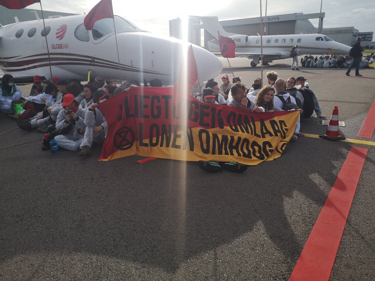 socialisme_nu's tweet photo. Vandaag doen wij mee met de acties op Schiphol. Kabinetten Rutte laten de klimaatcrisis escaleren en hebben het OV uitgekleed. Reizigers en OV-werkers zijn de dupe. In een wereld waarin onze behoeftes centraal staan, en niet winst, is er geen plek voor privéjets #krimpluchtvaart https://t.co/6ZsRZnp7Fa