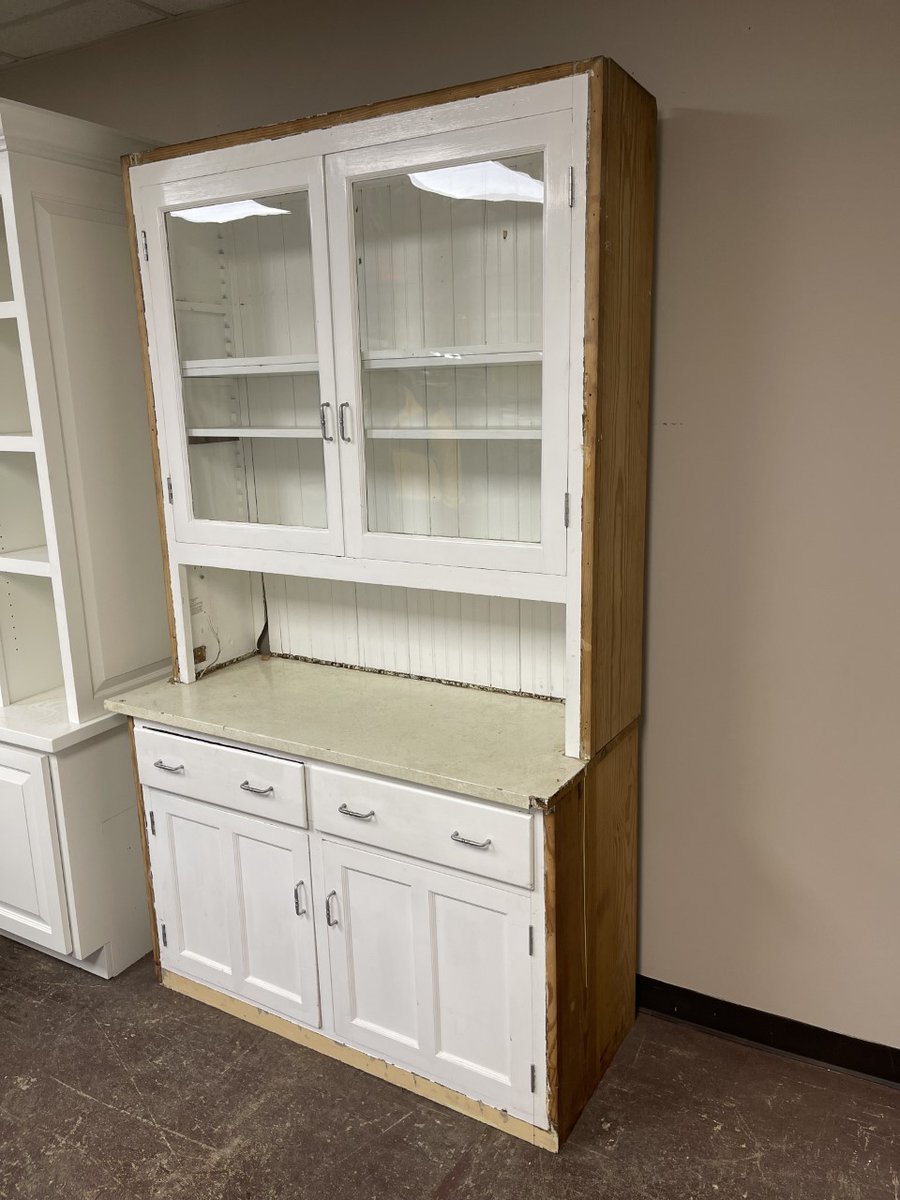 BuildingValue's tweet image. Vintage Mission-style step-back cupboard hutch. This hutch is constructed out of solid wood with a beadboard back and is painted white. Large shelf area with glass doors, open counter area, a base with 2 drawers and 2 doors. This piece measures 48” wide x 85” tall x 20” deep.
