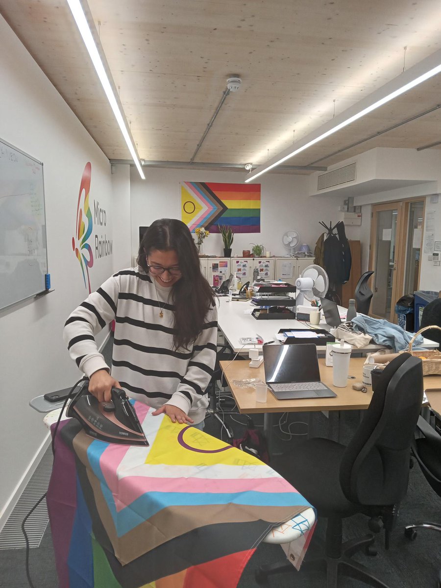 MicroRainbow's tweet image. When refugees move into our safehouses, they are  given a welcome pack with a new duvet and pillows and other items to help them settle in.
We also give them a flag - Camille is diligently ironing away in the Micro Rainbow office, making sure they're not creased!
