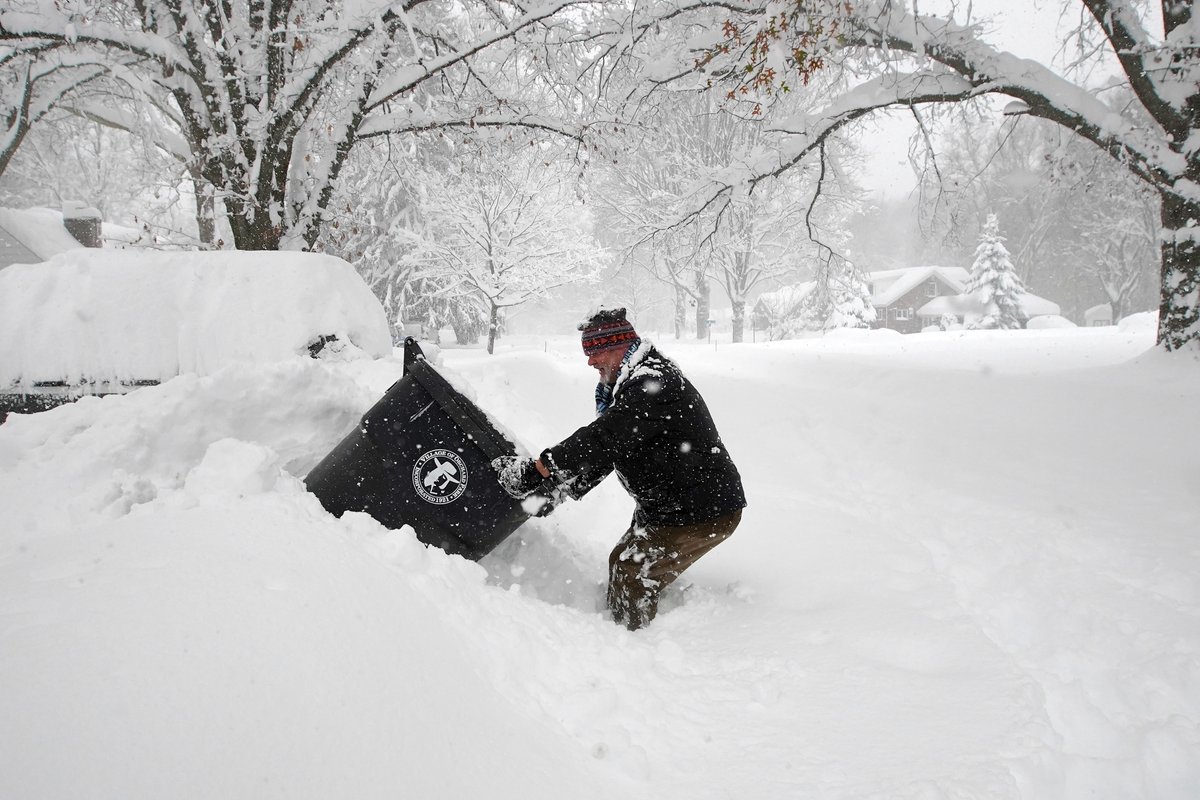 Jay Ruof tries to get his garbage tipper can out of a snow bank at his home in Orchard Park Friday, November 18, 2022.      (Mark Mulville/Buffalo News) #buffalosnow