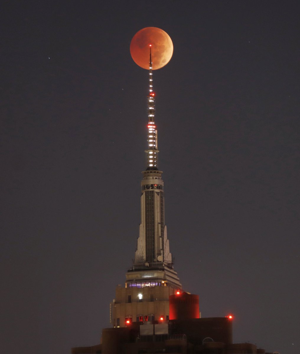 The totally eclipsed blood red moon passes behind the antenna on the Empire State Building in New York City, Tuesday morning in New York City #bloodmoon #LunarEclipse #beavermoon #newyork #newyorkcity #nyc