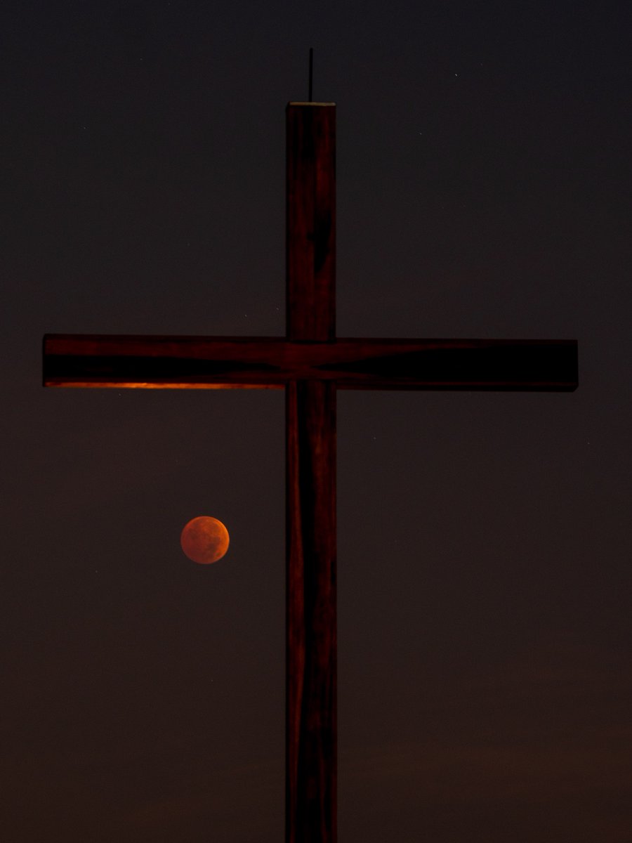 c_had's tweet photo. Woke up early for the eclipse. The moon was low in the sky, trying to hide behind the trees, so we drove up to our church to see it. Glen Mar is the highest point in the area, so its views are great. I got this picture of the moon with the cross out front. https://t.co/2GdcA4VIkK