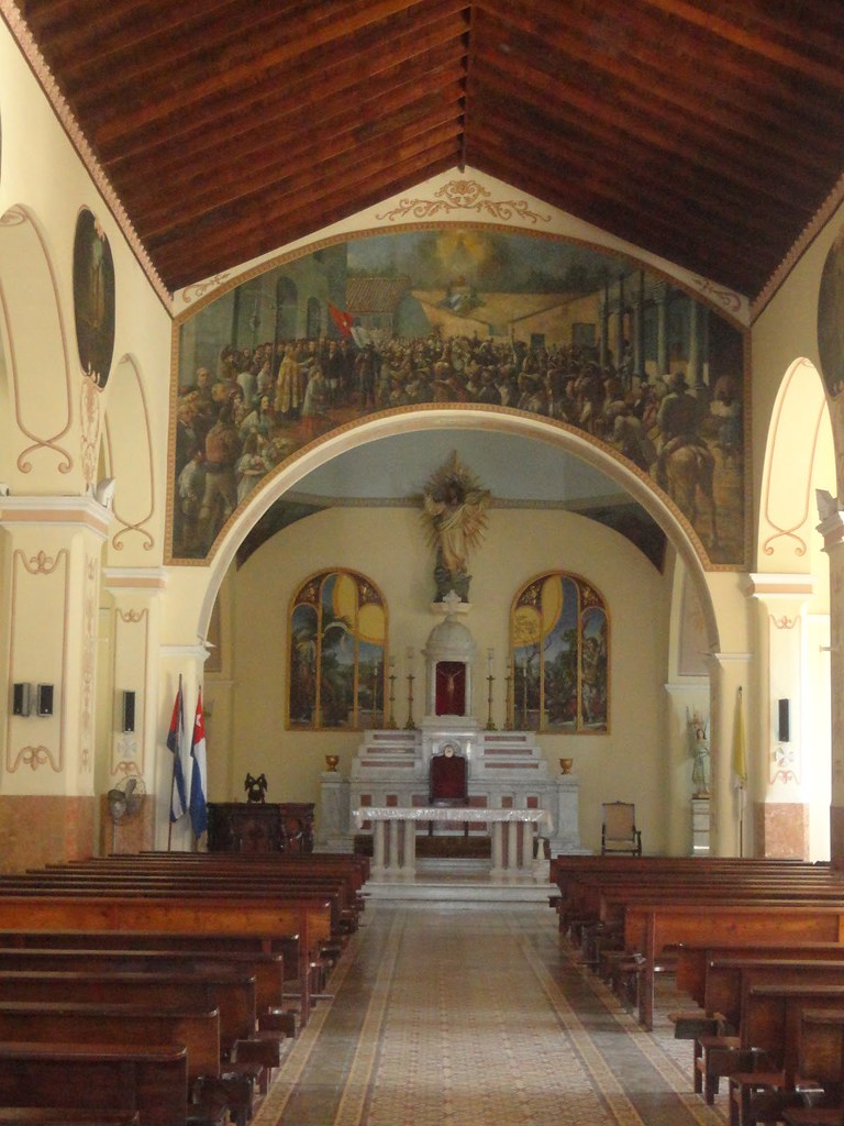 BaezLiutmila's tweet photo. La Catedral de Bayamo conserva un mural del pintor dominicano Luis Desangles que perpetúa el momento en el que el 8 de noviembre de 1868 el padre Batista bendice la bandera de Céspedes, acto que concluye con la interpretación de La Bayamesa por un coro dirigido por Manuel Muñoz. https://t.co/5GRJeUsEky