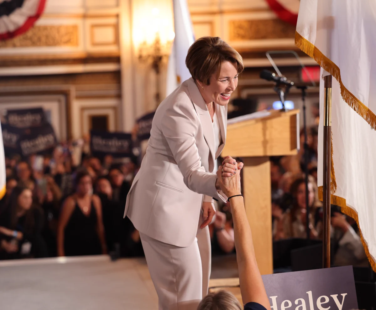 Photo of Maura Healey on stage and smiling at a rally