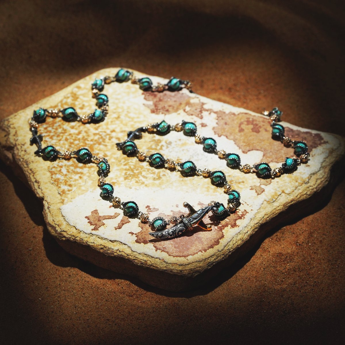 sevanbicakci1's tweet image. Fashioned from gold and silver, this chain features turquoise beads set in twisted milgrain enclosures- interspersed with granules formed to the likeness of mace heads. The dagger form, a signature motif in all Sevan Bıçakçı designs, functions here as a clasp-locking system.