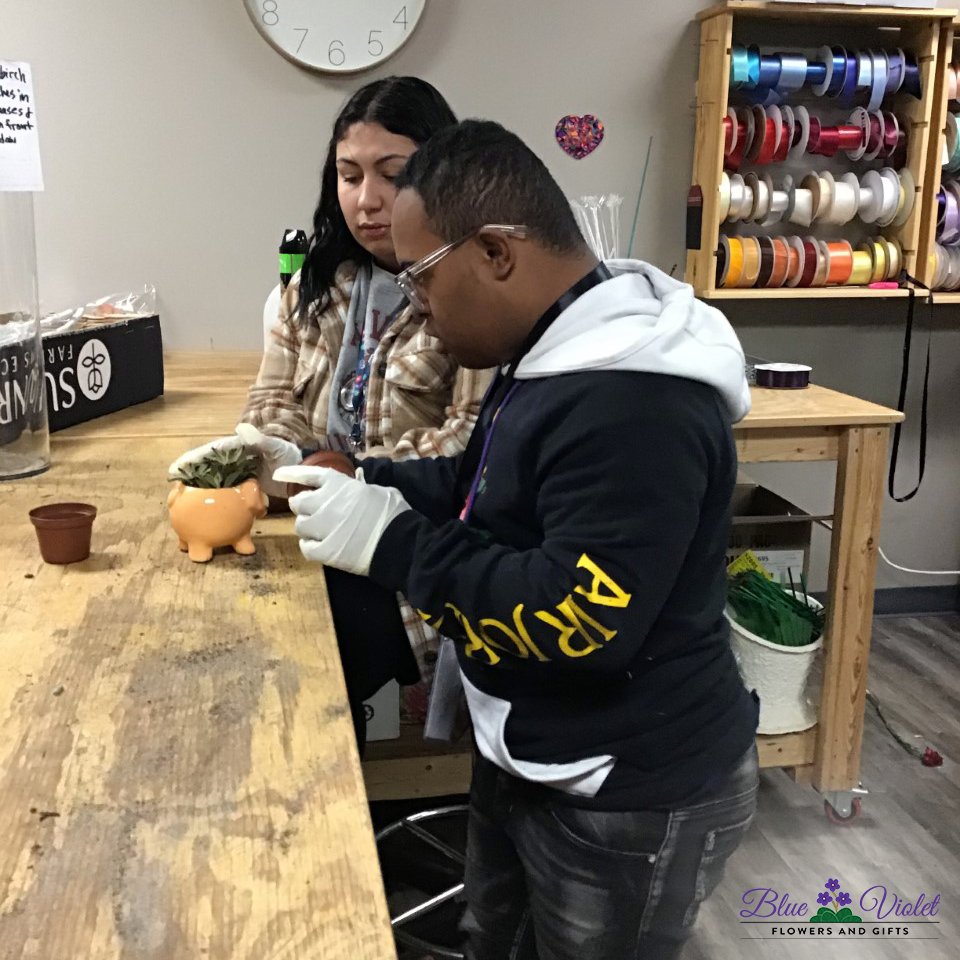 ArchwayPrograms's tweet image. Shakar, a Lower School student, is hard at work repotting succulent plants into their new homes, a collection of adorable ceramic pots. The repotted succulent plants will be a part of the inventory in our  Shop.  🎍🪴

#BlueVioletFlowersAndGifts #ArchwayPrograms #Florist #Plants