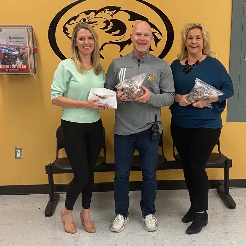Sedalia Middle School raised $544 through the Pumpkin Penny War. The money was donated to the Brendan Eisenmenger Student Impact Fund. Erica Eisenmenger and Deidre Esquivel accept the pounds of pennies--and cash--from SMS principal Brett Hieronymus.
