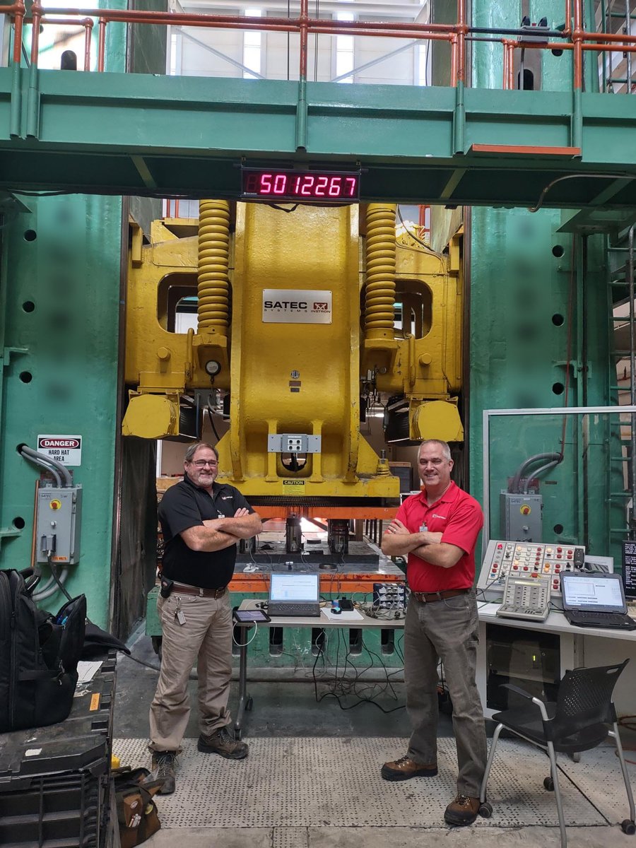 instron's tweet image. Field Service Engineers Doug Coffey and Todd Lehman calibrated a 5-million-pound (lb), 3 story tall, Instron SATEC machine this week. Here, you can see Doug and Todd with the 4-1million lb load cells and 2-600kN load cells used on the equipment, with 5,012,276 lbs on the readout!