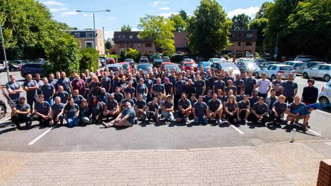 A photo of the entire Gears Tactics Development Team, taken in the Splash Damage car park in the sunshine.

