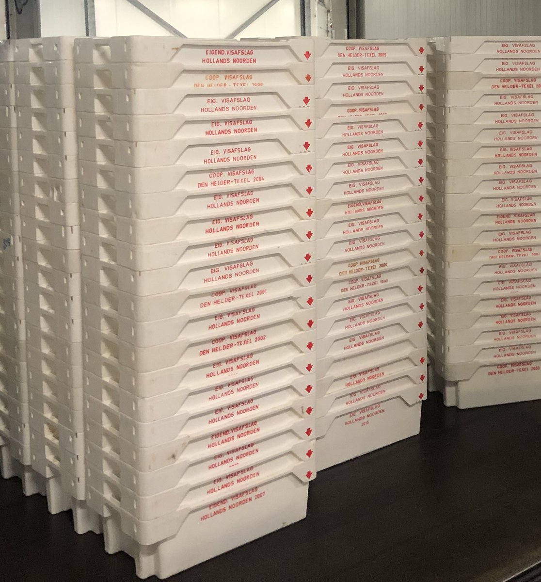 Een visloze vrijdag in onze afslag. Veel zullen er nog volgen. Links zoals het 25 jr geleden was. Nu een schone maar lege sorteer hal en 9.000 schone viskisten wachtend op wat niet meer komt. En een onttakelende vloot in de haven. We zijn in een slechte film terecht gekomen.