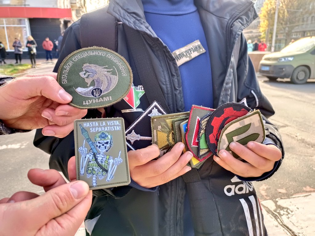 CristianSeguraA's tweet photo. Los niños en Jersón persiguen a los soldados para que les regalen las identificaciones de sus batallones. En la crónica de hoy cito a Danil, que ha conseguido 10 escudos. (Uno de ellos, parafraseando a Terminator, está dedicado a los prorrusos del Donbás) 
https://t.co/nmh3GKO4PW https://t.co/DQsCrcQD6o