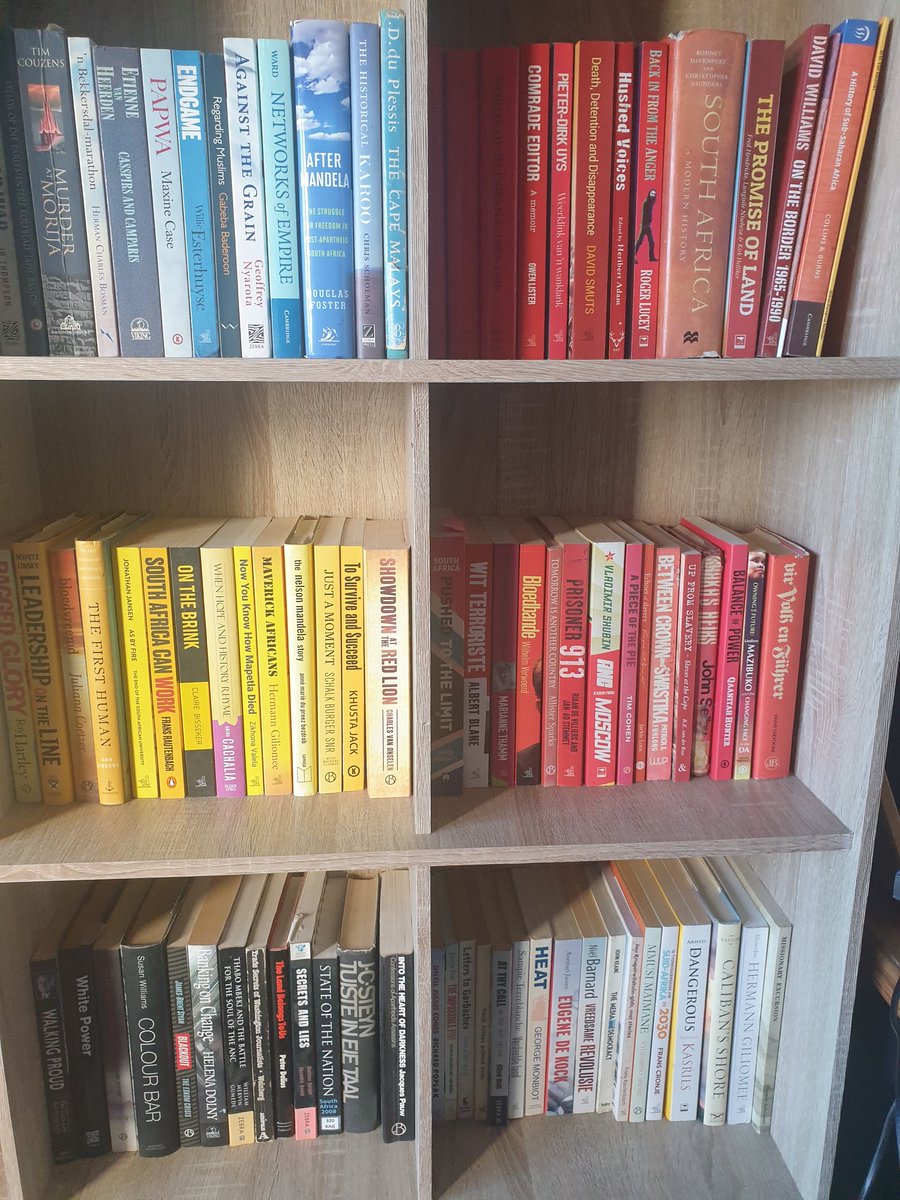 MaxduPreez's tweet image. This what happens when your designer/artist wife volunteers to rearrange your library: books are arranged according to colour rather than author or topic. It's so lovely