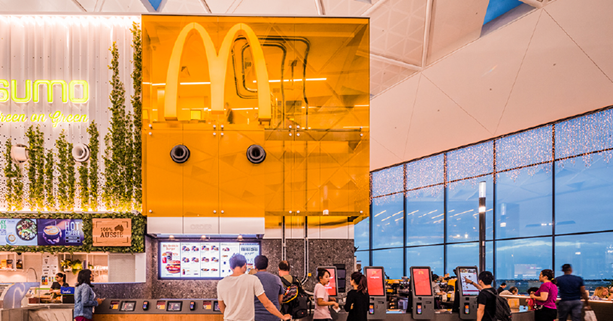McDonaldsCorp's tweet photo. One of the coolest McDonald’s restaurants is located inside Sydney International Airport. The kitchen and crew are perched above the counter, where they prepare and bag orders before putting them on a conveyor belt to be delivered to travelers. Innovative and beautiful! https://t.co/X9KaqIYwsy