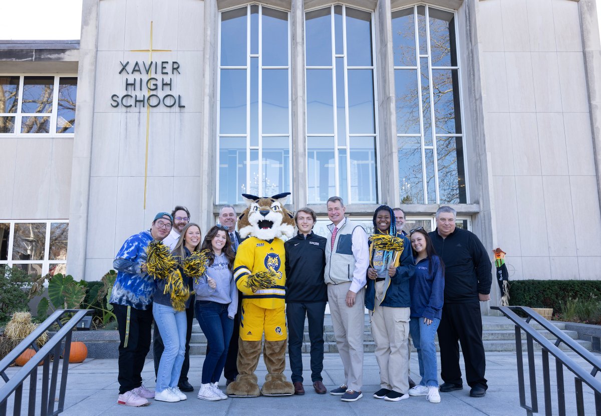 QuinnipiacU's tweet photo. Boomer, a team of student ambassadors and Chief Experience Officer Tom Ellett surprised the first two students admitted to the Class of 2027 this week. Welcome to #BobcatNation Tessa @Danburyk12 and Timothy @XavierHighCT! https://t.co/vytYHdknNh