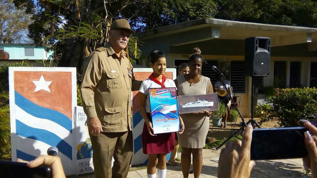 AriannaIsasi's tweet photo. Irialis Matos Nazco, estudiante de la Escuela Especial Simón Bolívar del municipio #Venezuela, ganadora nacional del concurso Amigos de las FAR,  recibió su reconocimiento de manos del Héroe de la República de Cuba, Cr. Orlando Cardoso Villavicencio #CubaMined #LatirAvileño. https://t.co/jaHw8ycgRg