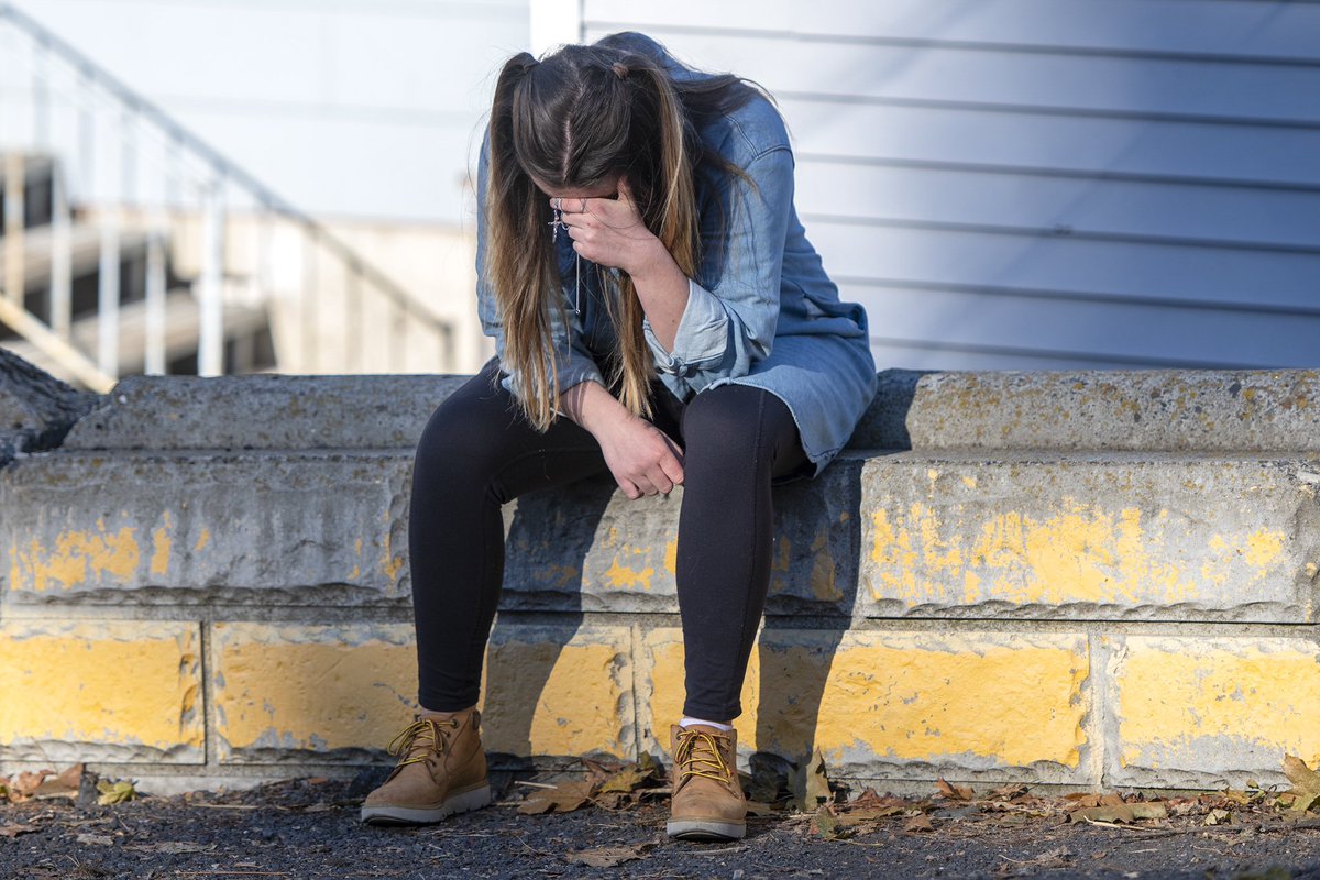 University of Idaho student Alaina Tempelis, of Seattle Wash., prays with a cross in her hand, Thursday, Nov. 17, 2022, in Moscow, Idaho, outside of the home where four fellow students were recently murdered. (Zach Wilkinson/Daily News)