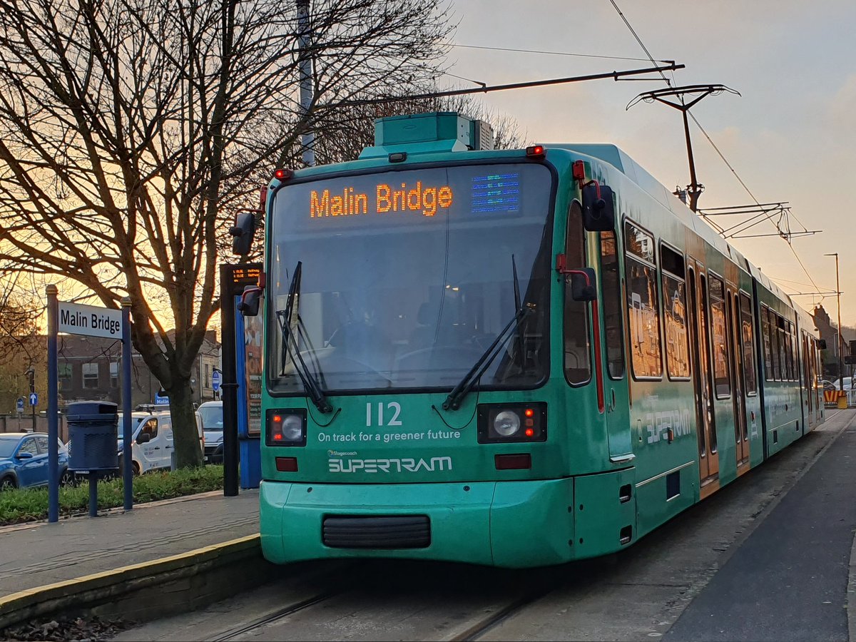 JamesTGlossop's tweet photo. As the sun sets in the distance earlier on the first day of December, Sheffield Supertram 112/mi bird/The Green Goddess sits at Malin Bridge. (01/12/2022) #MalinBridge #Sheffield #Supertram #TheGreenGoddess #SouthYorkshire @JedKendray @303032T https://t.co/UB9kKUeV0t