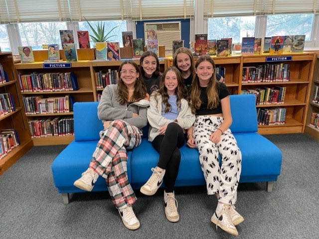8th graders reading in the library on PJ Day