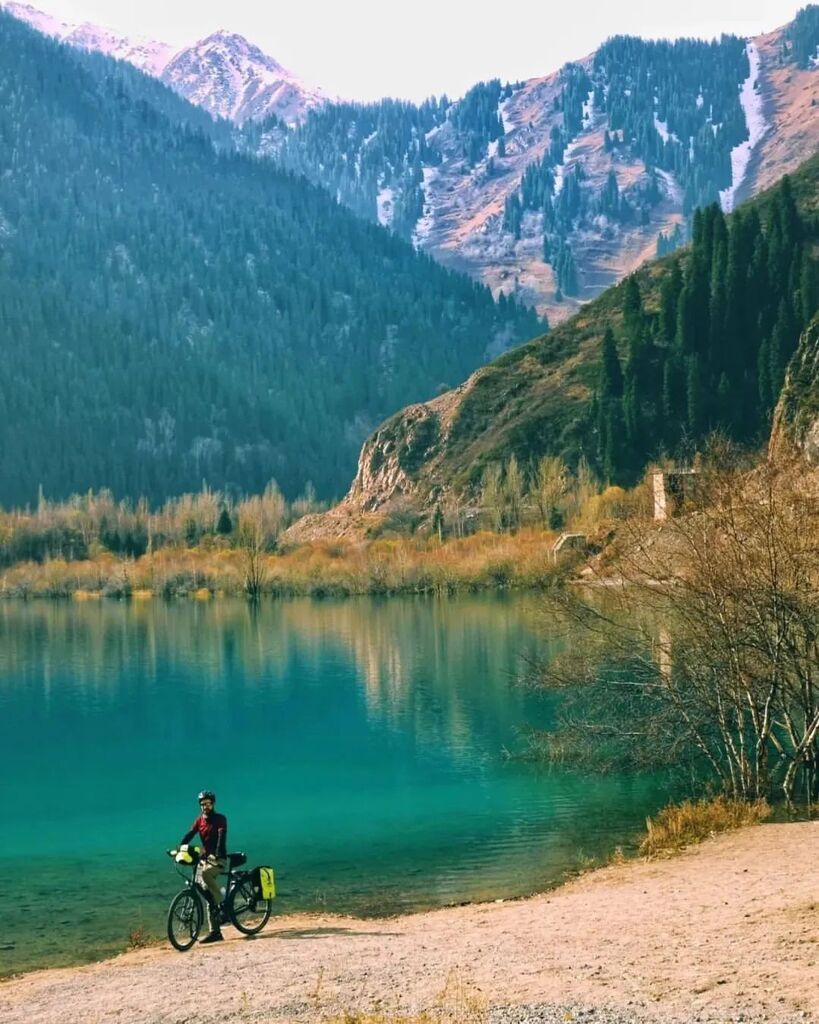 'Turqoise waters in Kazachstan, Lake Issyk! 🇰🇿 We cycled 20km up to the mountain lake, it took very long! And in less than half an hour back down😅 On top there were a lot of (touring)cars and we got stared at like we are two aliens on crazy bicycles… instagr.am/p/ClMBUMAN0k1/