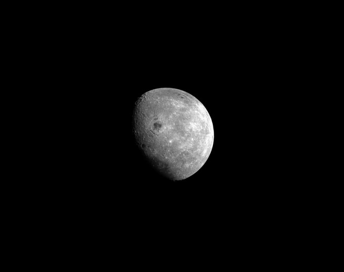 The Moon appears against the blackness of space. Craters are visible on the grey lunar surface.