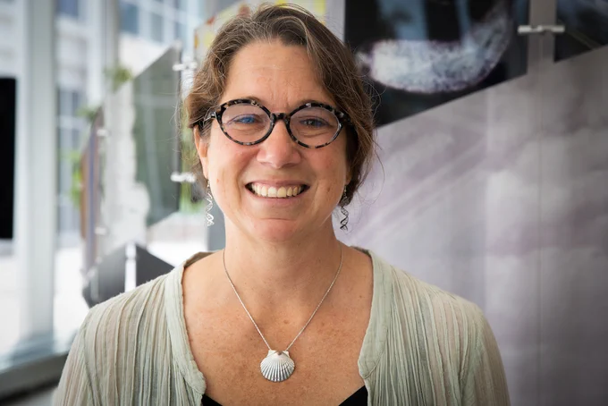 Dr. Rachel Whitaker smiles for the camera inside the main entrance of IGB at Illinois.