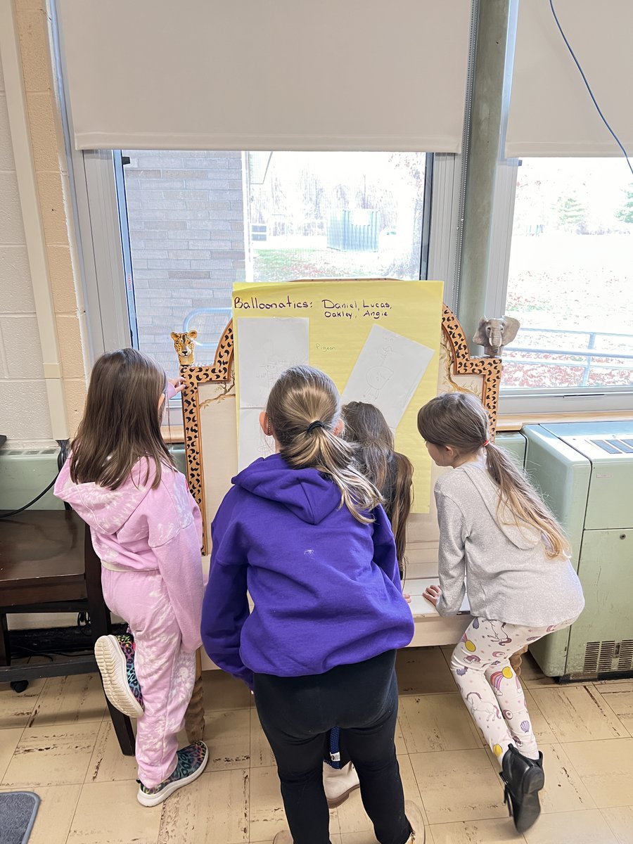 Gallery walk during the balloon design process. After groups chose a book character, each student made their own drawing. S's viewed all the groups' designs taking inspiration from each other's ideas. After each group came to a consensus on one prototype design.