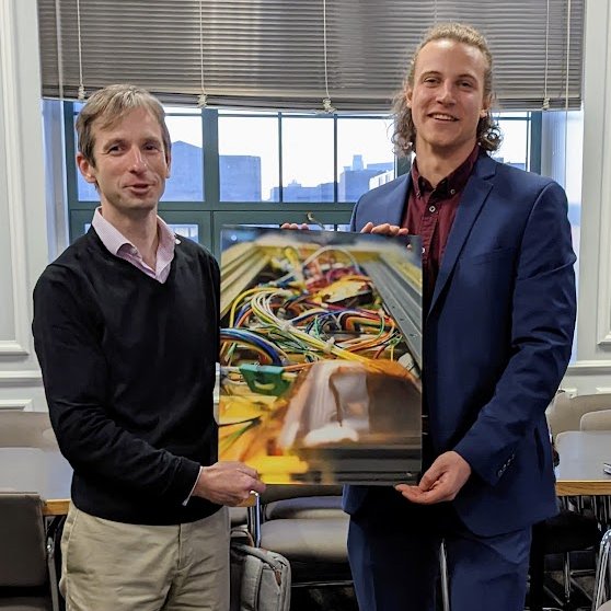 Congratulations to ME graduate student Dr. Emil Atz, who successfully defended yesterday! Here he is presenting to his advisor, Prof. Brian Walsh, a photograph of CuPID's wiring, showing that there is art in engineering!