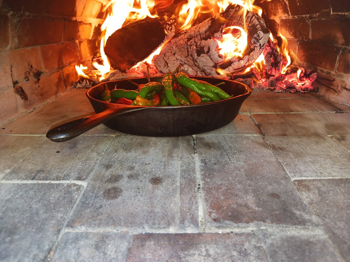 110 pizza doughs rising inside the house. Heating up the pizza oven and roasting long hots outside.