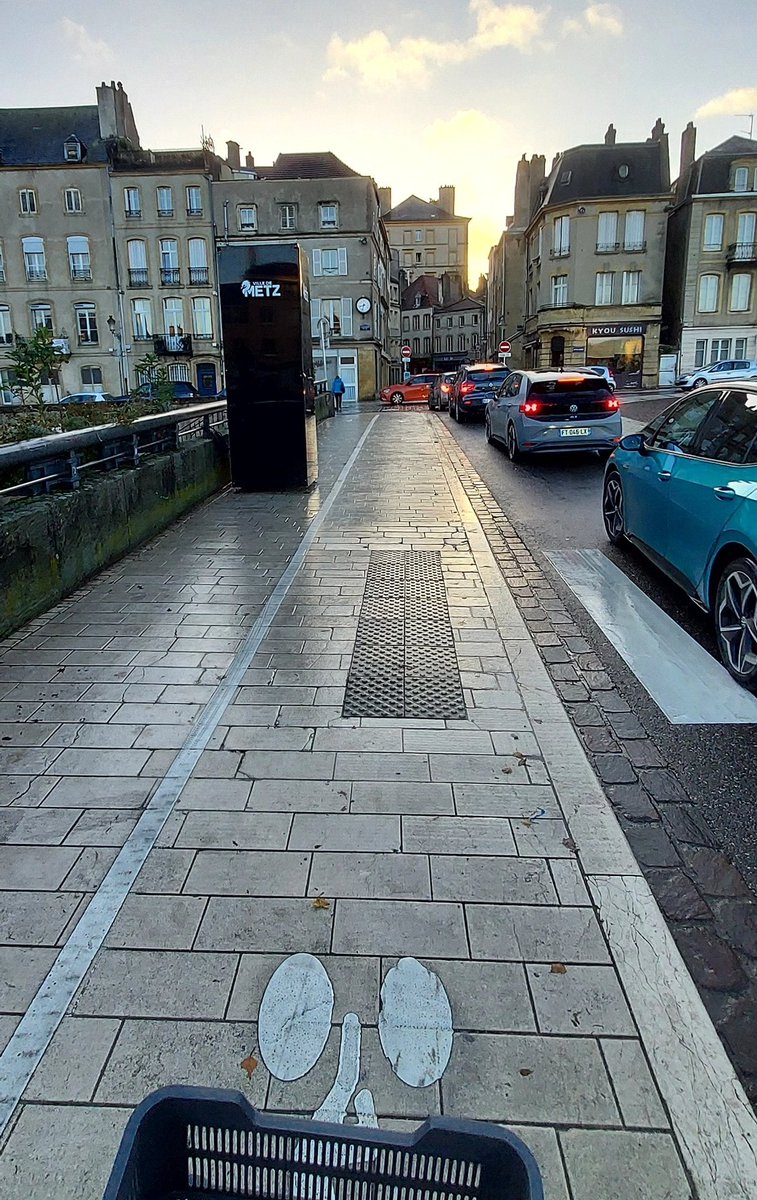 VelorutionMetz's tweet photo. Féerie de Noël à Metz : on condamne un trottoir, et on force les piétons sur une infra cyclable, pour laisser place à ce machin (un projecteur j'imagine). Personne à la mairie n'a remarqué que le moyen pont est blindé de piétons et vélos toute la journée ? https://t.co/3XM7D0kYyx