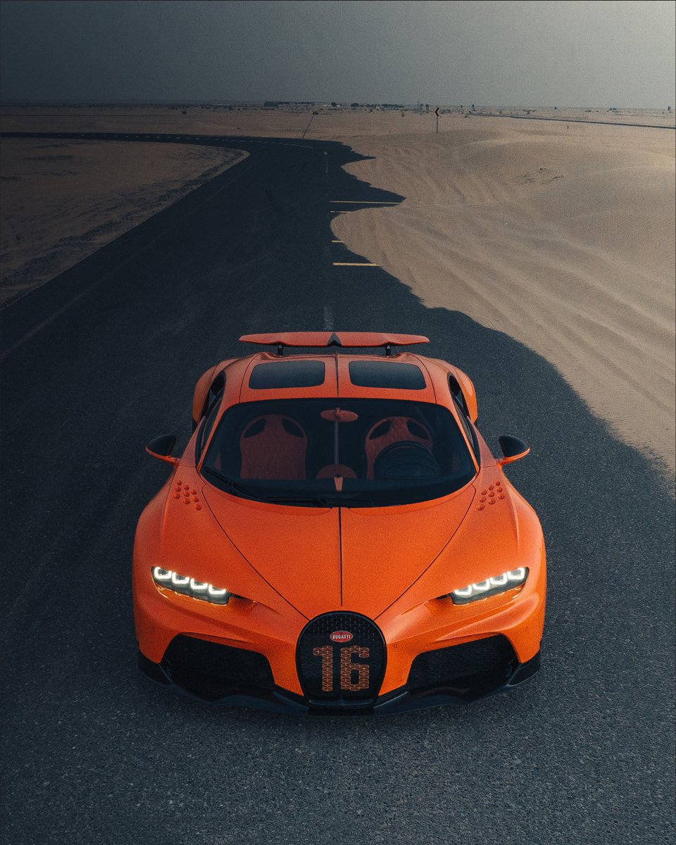 Captured just before dusk, this #BUGATTI tangerine-colored longtail prowls on the empty Dubai desert road. With 1,600 PS and a possible 440 km/h top speed, the  CHIRON Super Sport represents the pinnacle of longitudinal performance. 

#CHIRONSuperSport
–
bugatti.link/consumption