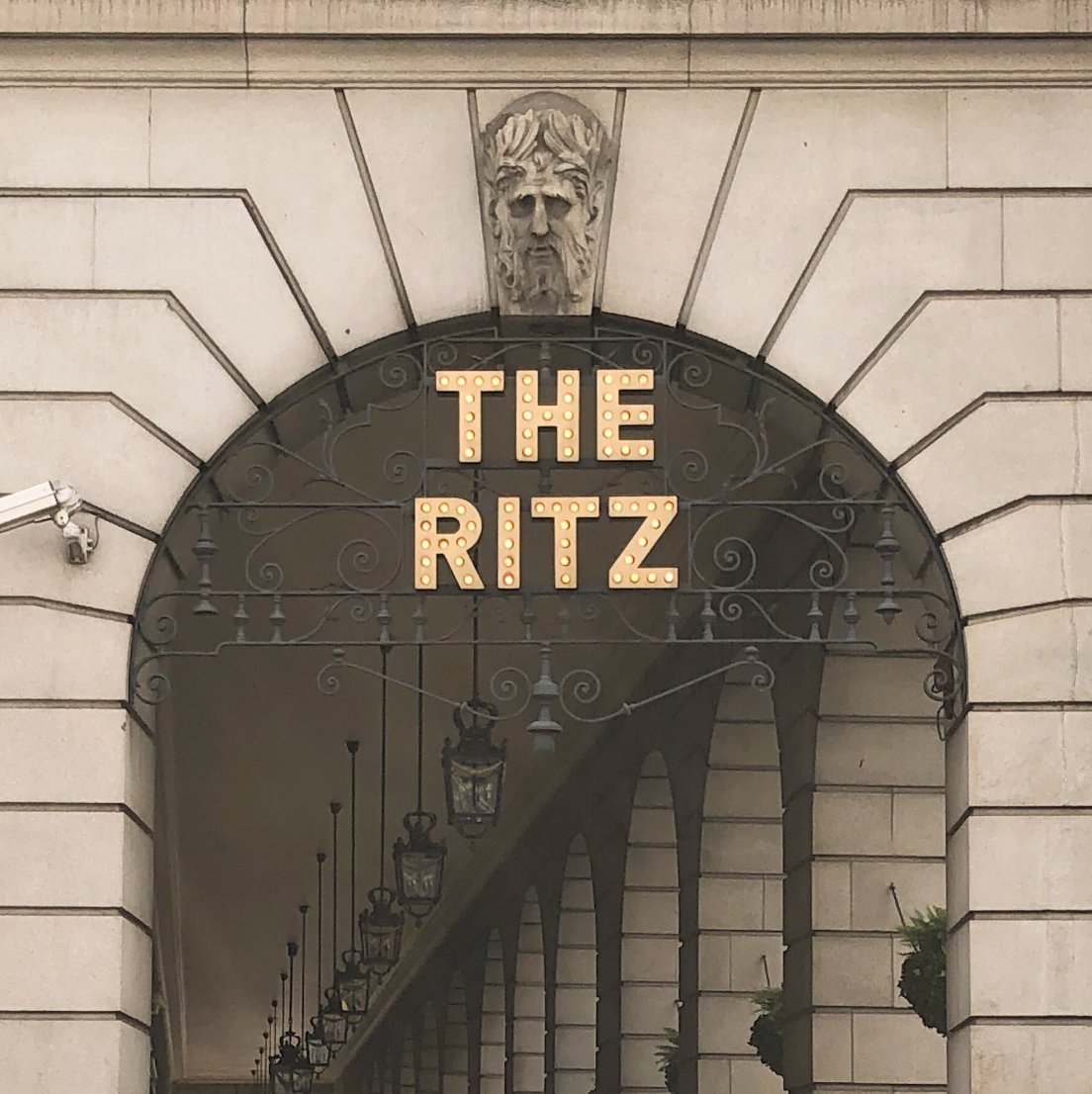 photo of the ritz logo hanging from a stone arcade