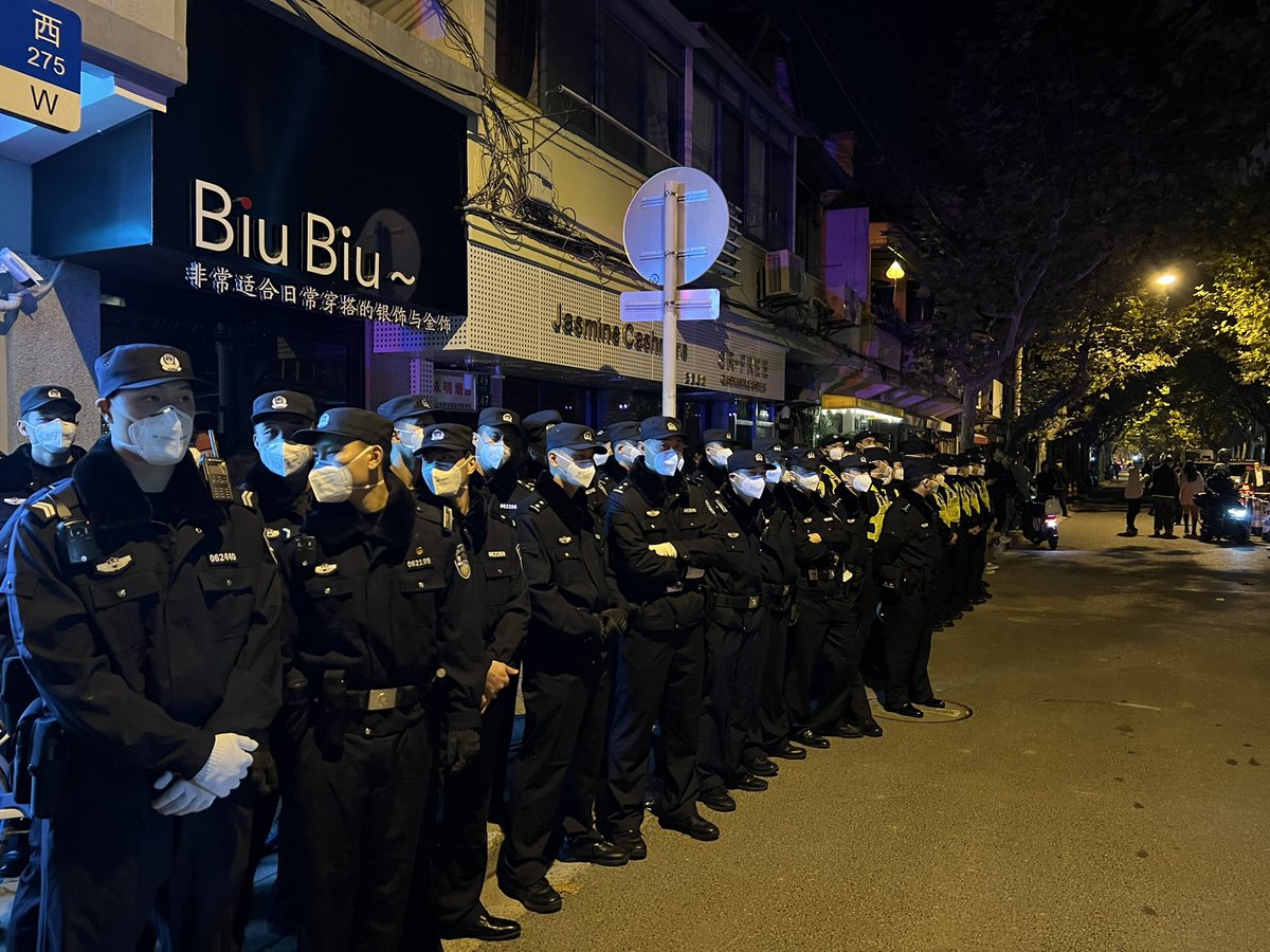 brandhane's tweet image. Shanghai tonight. Protest at vigil for the dead in Urumqi. “Freedom. No more test. Throw off your masks” and The March of the Volunteers. Surrounded by police on all sides. 500-1000 people.