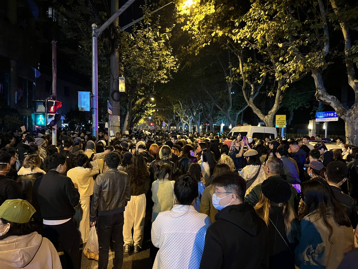 brandhane's tweet image. Shanghai tonight. Protest at vigil for the dead in Urumqi. “Freedom. No more test. Throw off your masks” and The March of the Volunteers. Surrounded by police on all sides. 500-1000 people.