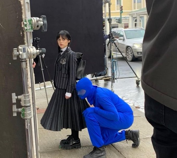 Behind the scenes photo of Jenna Ortega and Victor Dorobantu, the actor plays Thing on Wednesday 