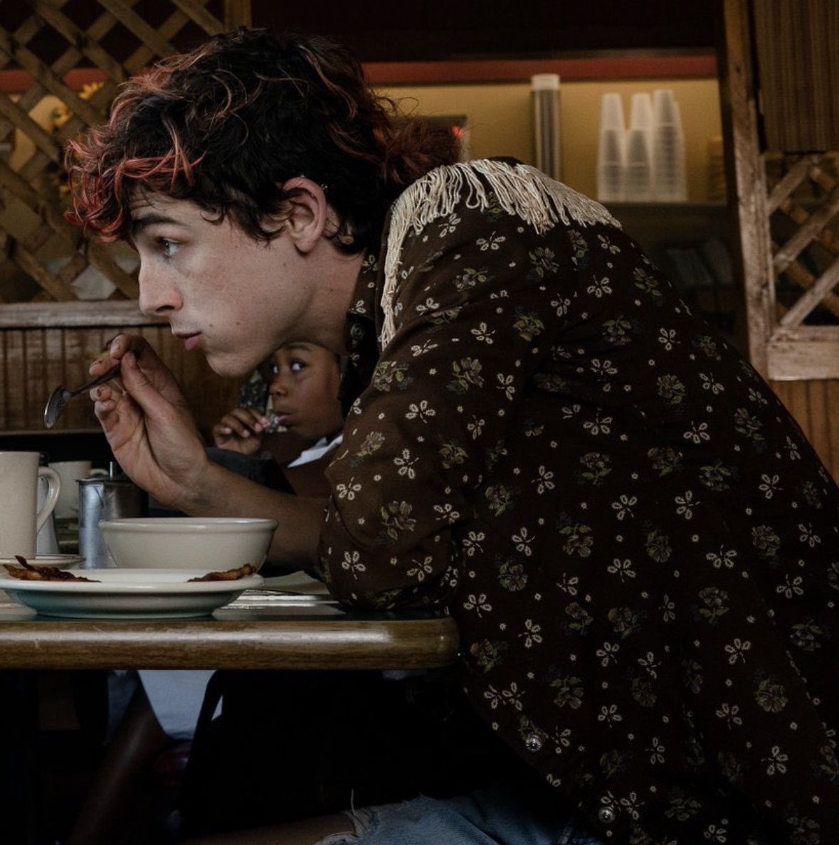 rebellevague's tweet photo. America degli anni 80 on the road, musica rock nelle orecchie, jeans strappati, camicie floreali e t-shirt sudice: inauguriamo la rubrica #PulpFashion con tutti gli outfits di #TimothéeChalamet in #BonesandAll. https://t.co/VFGjc0RtfU