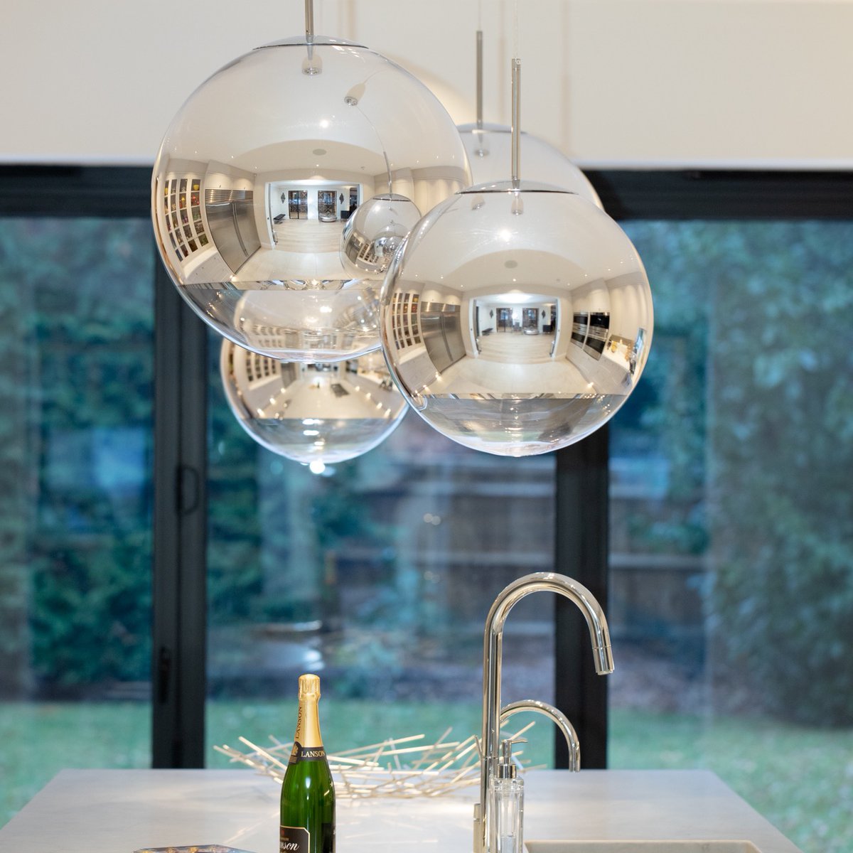 Standout, make a statement. Making your kitchen your own can be achieved as simply as hanging an elegant, eye-catching lighting creation. In this kitchen you can see the impact; the chrome pendants reflects the room from centre stage. Its almost like a piece of art on display.