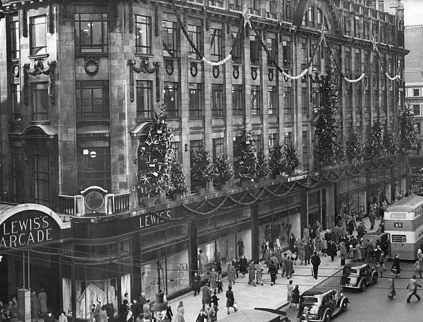 McrHistory's tweet photo. Christmas decorations adorn the outside of Lewis's, Market St, Manchester. 1949. The building is now occupied by Primark. The Arcade on the left was a covered L-shaped walkway running from Market Street and out onto Mosley Street. The Arcade entrance shown here is now Caffe Nero. https://t.co/J0Jwp0hdY1