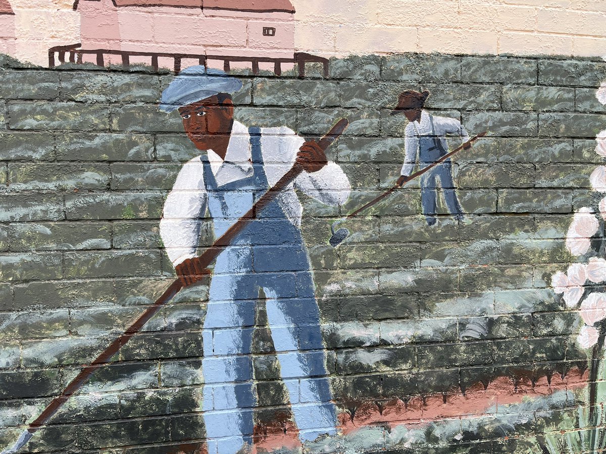 Mike_Hixenbaugh's tweet photo. When you’re the new kid in Slaton, Texas, this mural—painted in 1998 by prisoners—is one of the first things you notice. It shows Black workers toiling in a cotton field as a white farmer peers down from the seat of a tractor, along with the slogan “Slaton: Your Kind Of Town.” https://t.co/7RxqL6vA8e