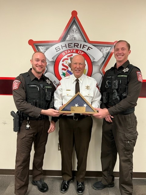Deputies Aaron Finigan and Matt Marass presented Sheriff Campbell and SCSO with an encased flag flown during U.S. operations in East Africa. The two recently returned from a 10-month deployment in support of Combined Joint Task Force - Horn of Africa.