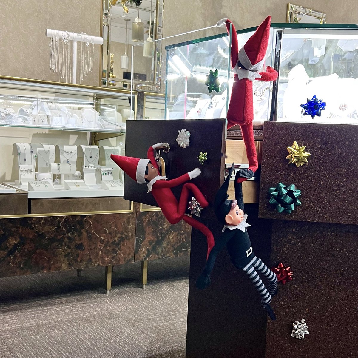 By bow they go, to the octagonal case,
Where they see diamonds and gold all over the place!
Pendants, and earrings and shiny bright rings,
Our elves can barely wait to play with these things!