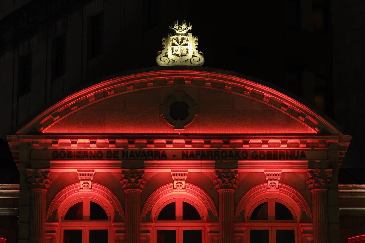Fachada del Palacio de Navarra iluminada de color rojo.