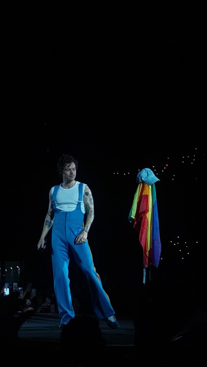 HLDTour's tweet photo. Harry looking at the Pride flag on his mic stand. 
#LoveOnTourBuenosAires #Night1
3.12.22

📸: Sebasgazzoli https://t.co/9UVzw2UpQ9