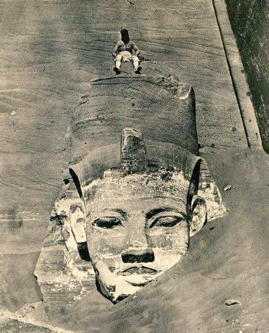 #AncientSiteSunday: a fantastic photo of one of the colossal statues from the main entrance to the Great Temple of Abu Simbel, #Egypt, mostly covered by sand. It was taken by Maxime Du Camp in 1850. An assistant climbed to the top of the head of the colossus, probably...1/2