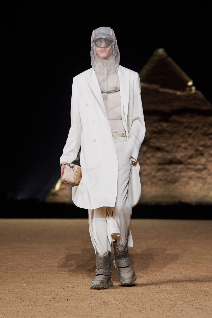 Dior's tweet photo. The Egyptian desert proved the perfect setting for a #DiorMenFall 2023 by Kim Jones https://t.co/41F1mpyyye mood of futuristic performance wear, with pocketed and hooded techno fabric jackets accessorized with molded and 3D-printed boots and mirrored eyewear. https://t.co/xUil3CtmtS