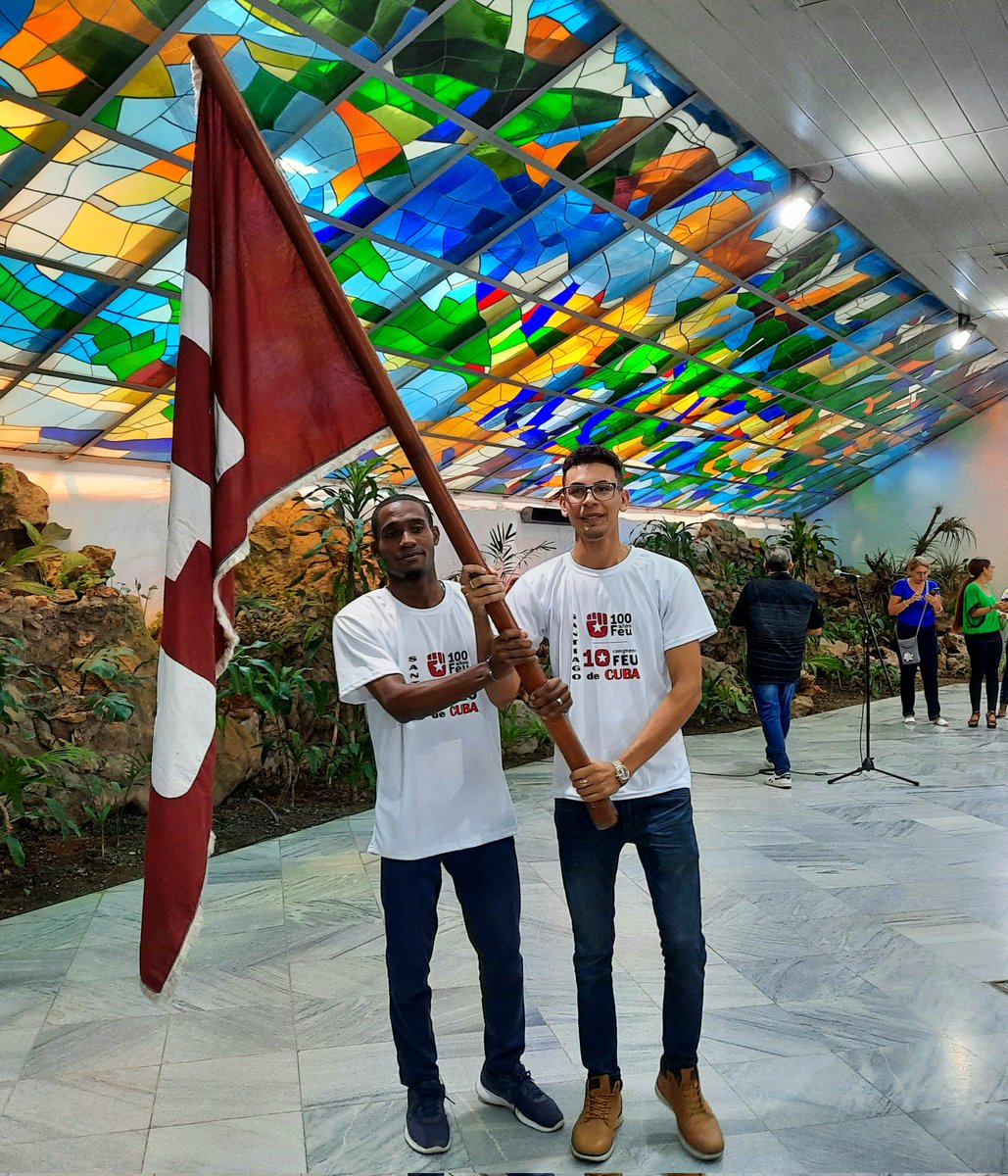 AlmaMater_Rev's tweet photo. 🤝🏻 Karla Santana, junto a José Ramón Monteagudo Ruiz, primer secretario del Partido en Santiago de Cuba, entregaron la bandera de la FEU que marcará la participación de los delegados e invitados a la magna cita de los universitarios cubanos. https://t.co/BaVqWWdOV9