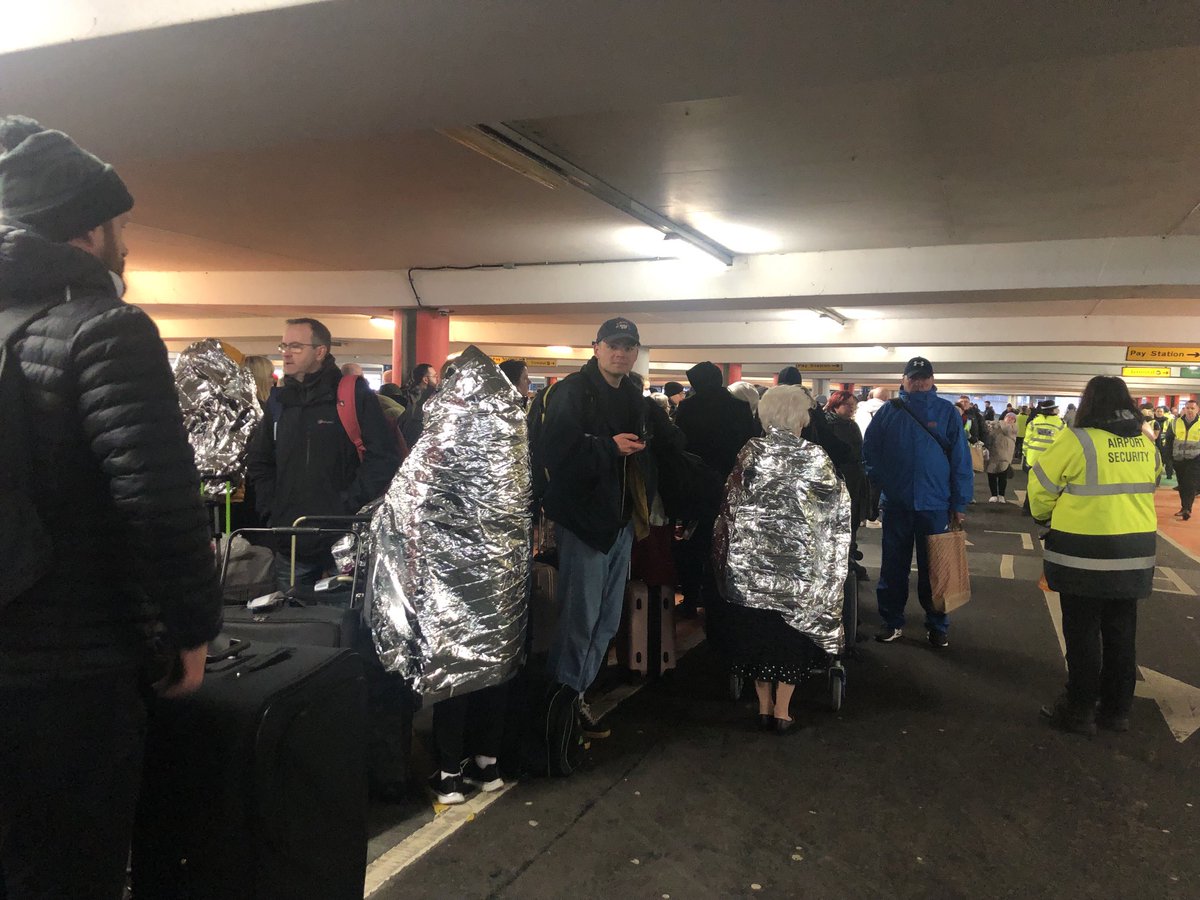 Hundreds of passengers - some with foil blankets at a car park at Glasgow Airport after reports of a suspicious item.