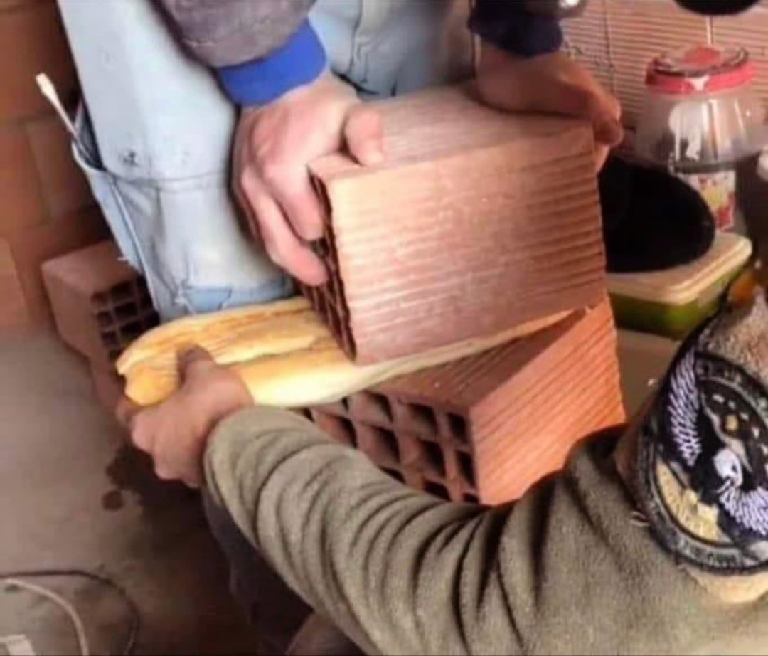 İki tuğlanın arasına ekmek sıkışmış onu çıkarmaya çalışıyo inşaatçı abilerimiz...