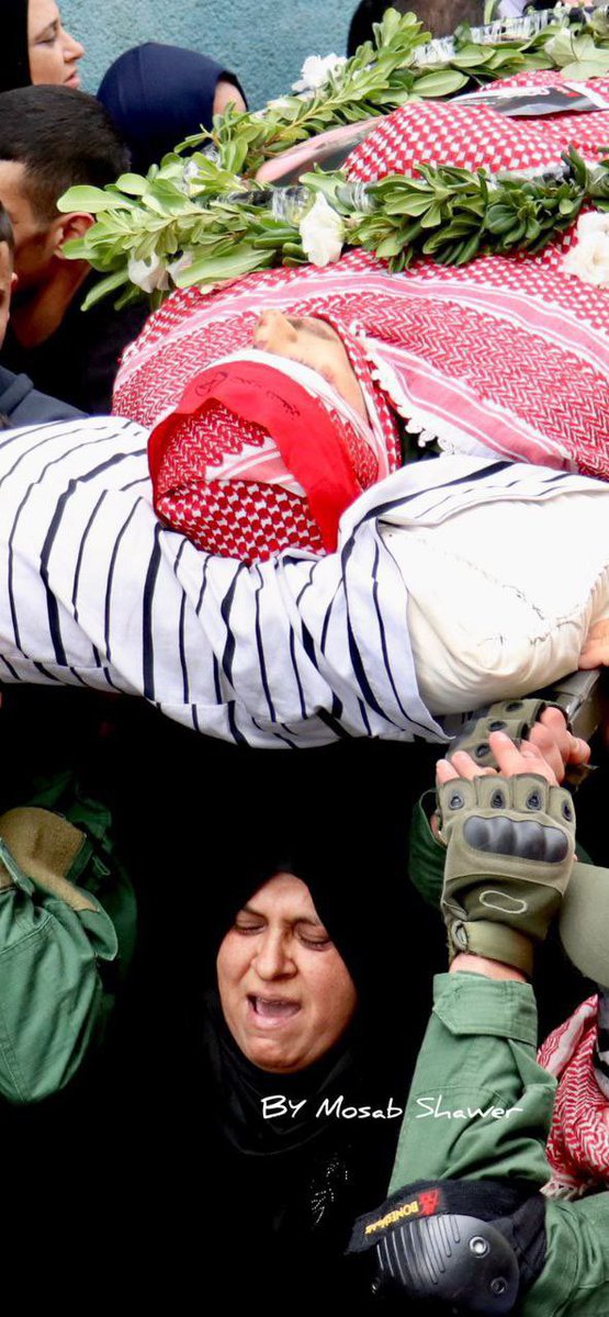 Timesofgaza's tweet photo. Mother of Omar Manna carries her son’s dead body during his funeral. The slain Palestinian young man was fatally shot by the lsraeli occupation forces during a military dawn in Dheisha camp, Bethlehem. https://t.co/qKLOU49BK6